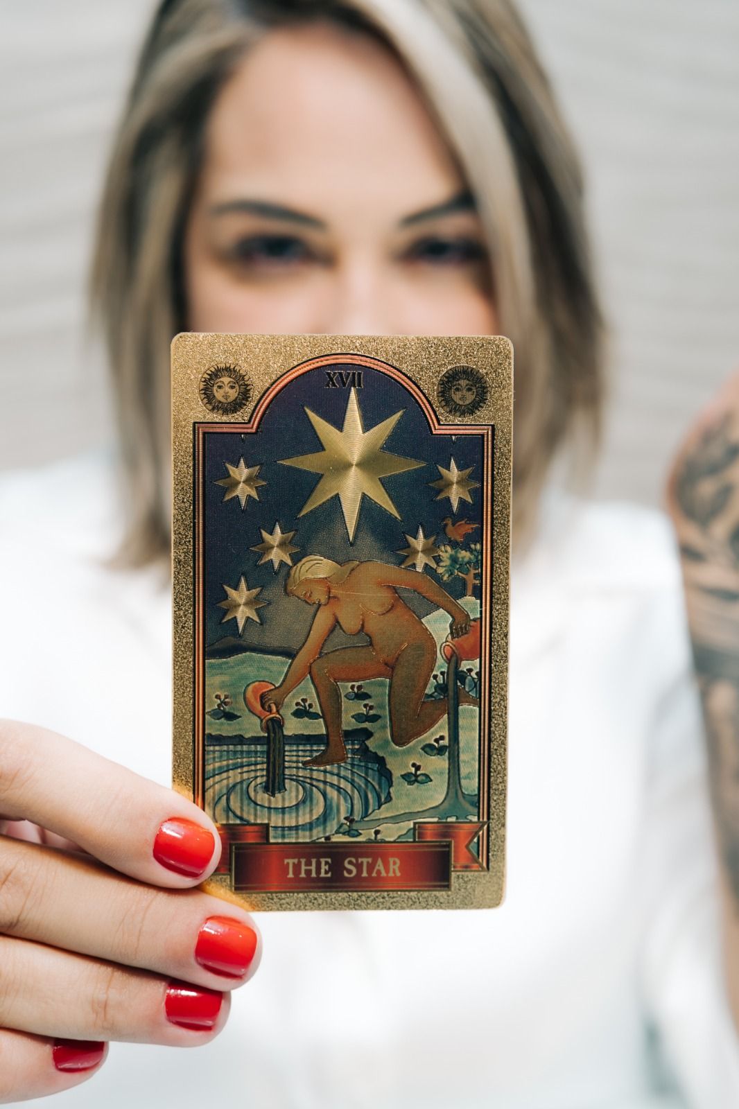 Mariah segurando a carta A Estrela do tarot