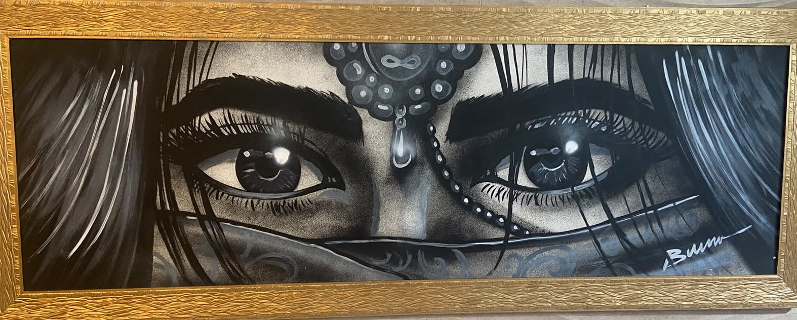 Quadro em preto e branco com olhos femininos velados, em moldura dourada